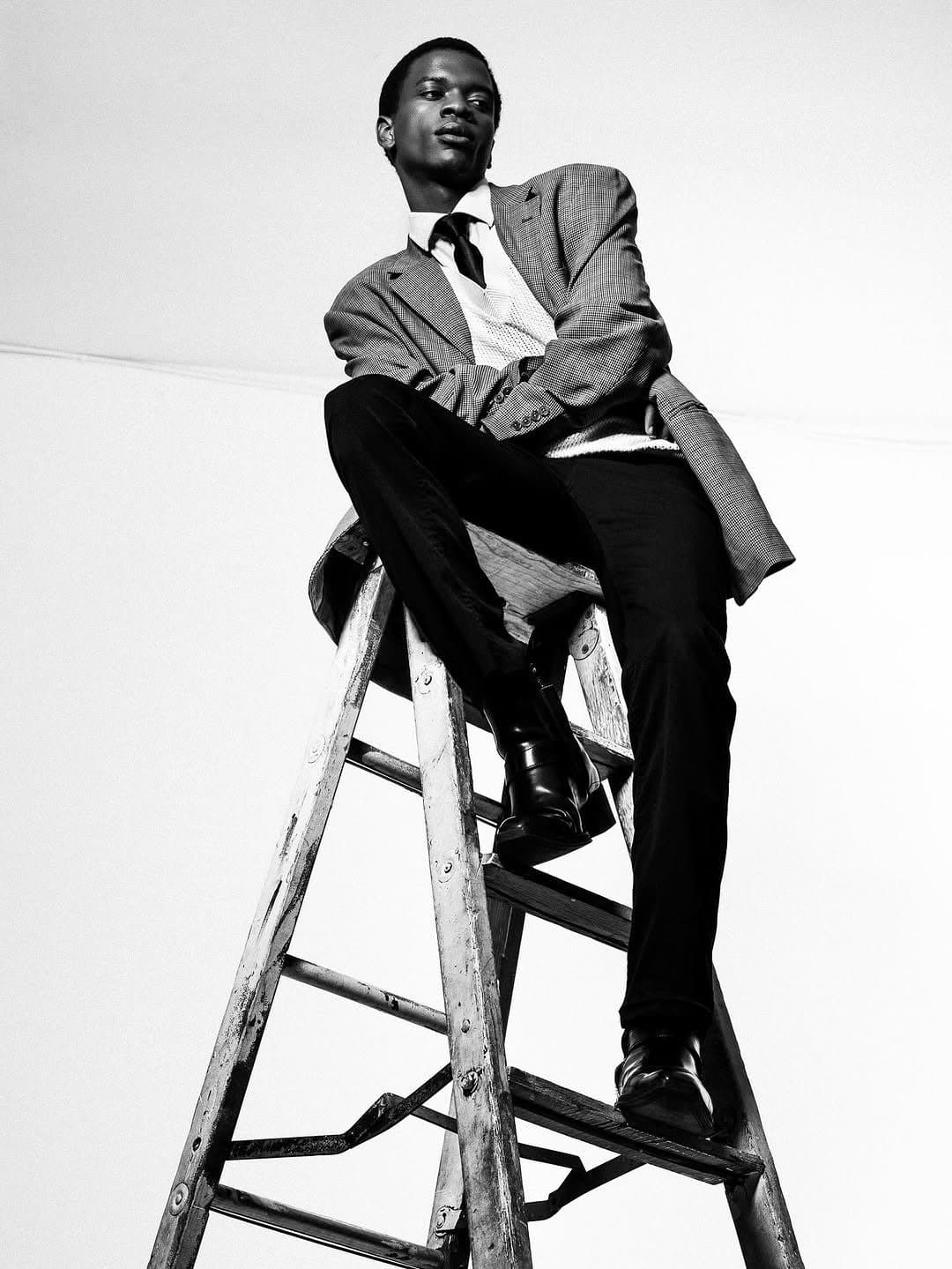 Writer seated on a step ladder, studio portrait