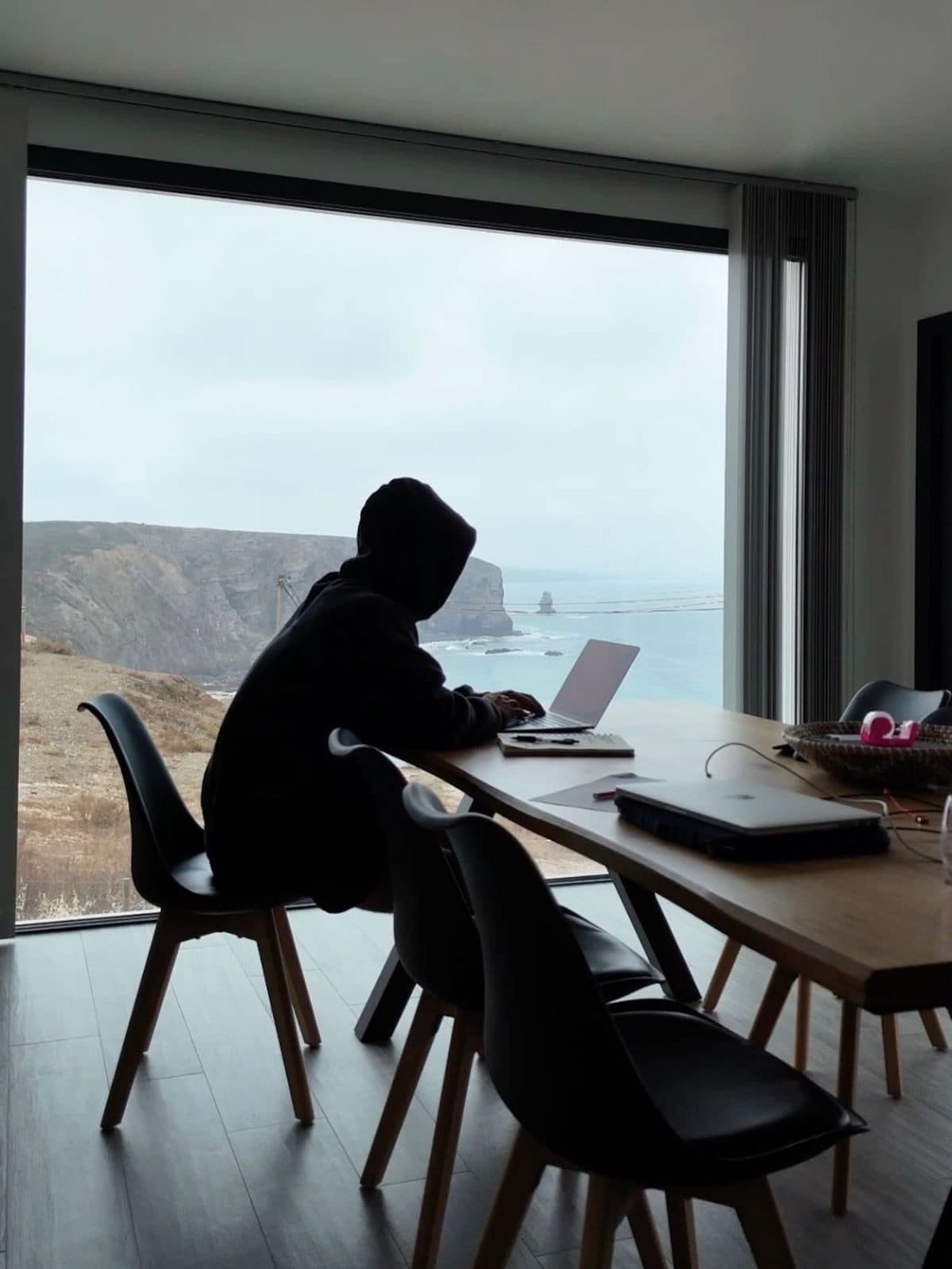 Writer working at a desk against a coastal window